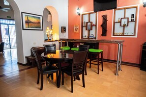 Un espace repas comprenant une table ronde, quatre chaises et un comptoir de bar.