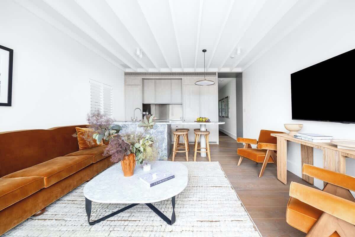 A modern living room with a sofa, coffee table, and dining area.