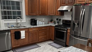 Una cocina moderna con armarios de madera, electrodomésticos de acero inoxidable y suelo de mármol.