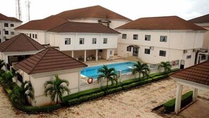 Un ensemble résidentiel comprenant plusieurs maisons, une piscine et une cour dallée.