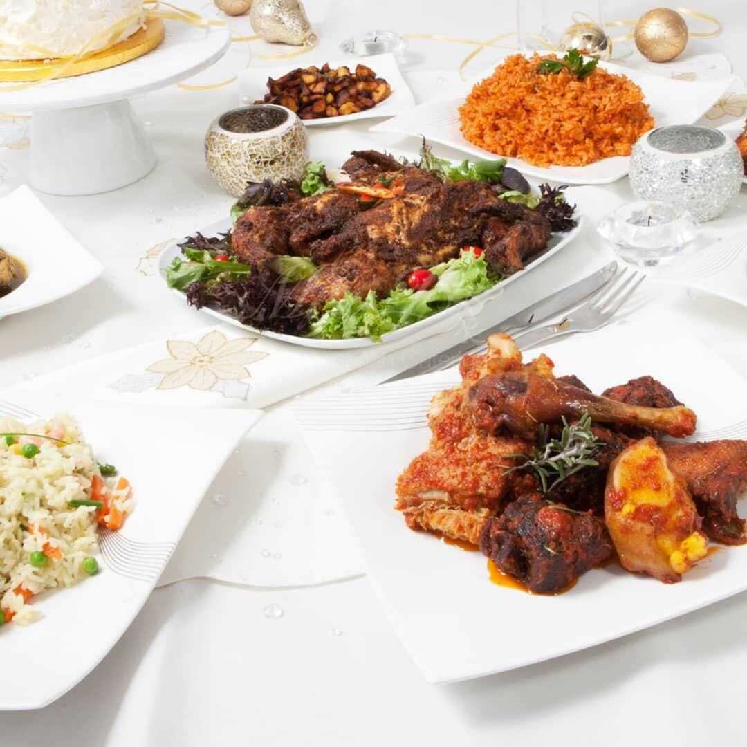 Una mesa servida con diversos platos, incluyendo carne asada, arroz y ensaladas.