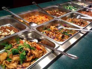 A buffet with various dishes including stir-fried vegetables, noodles, and meat. - Impeccable Hotel by HomeVille Plus Benin (Benin City)