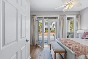 A room with a bed, bench, and a view through a door to an outdoor area. - SeaQuinn Beach House in 30A | 12,000 sq' Resort Pool | 4 Bikes | My Beach Getaways (Seacrest Beach)