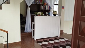 A living room with a staircase, a bookshelf, and a rug. - The Dream House  (Quito)