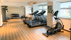 A gym with treadmills, an elliptical, and free weights.
