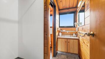 Interior de madera con ventana, un lavabo y armarios.