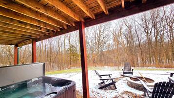 A wooden deck with a hot tub and outdoor seating.