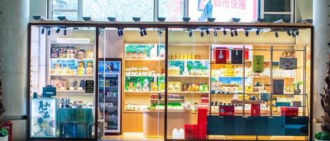 Una tienda luminosa con puertas de cristal y estantes llenos de diversos productos.