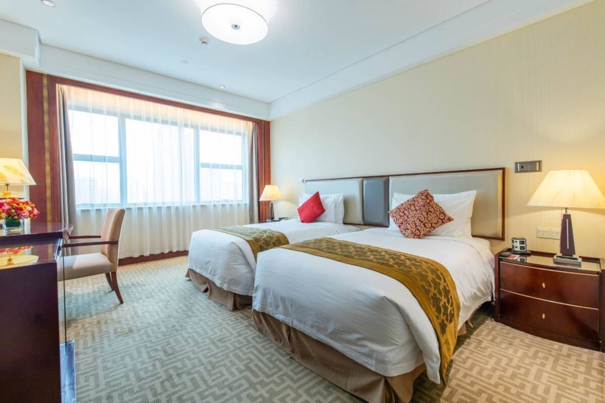 Una habitación de hotel con dos camas, un escritorio y una silla.