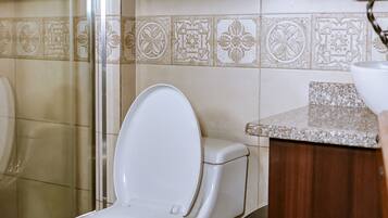 Un baño con inodoro, ducha y lavamanos.