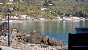 Vista costera con costa rocosa, edificios y cielo despejado.