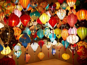 Een verzameling kleurrijke lampionnen die in een kamer hangen.