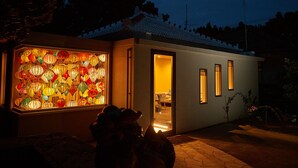 A modern house with a glass door leading to a room. - ADAN RESORT -LANTERN- (Motobu)
