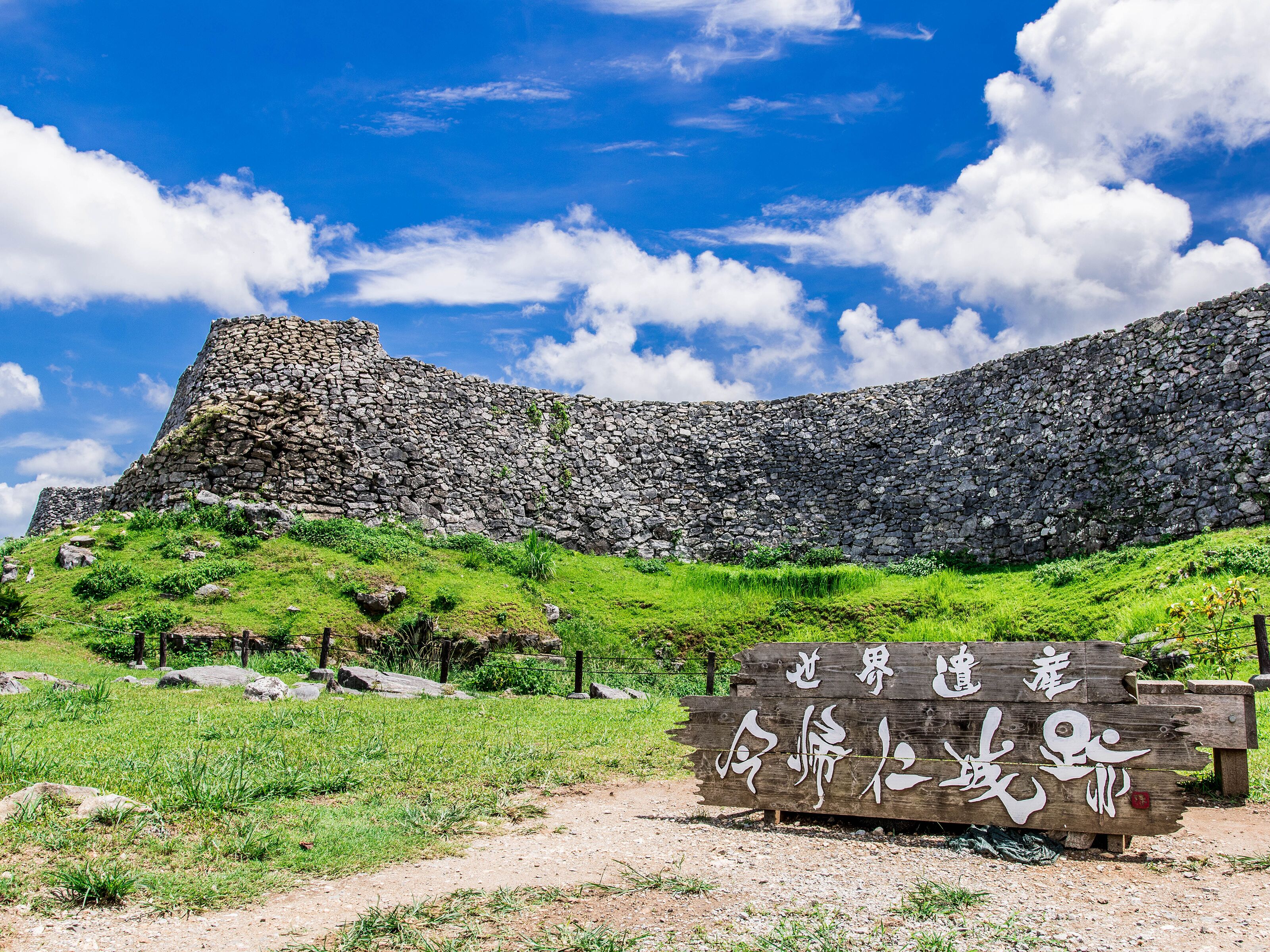A stone fortification with a wooden sign in front.