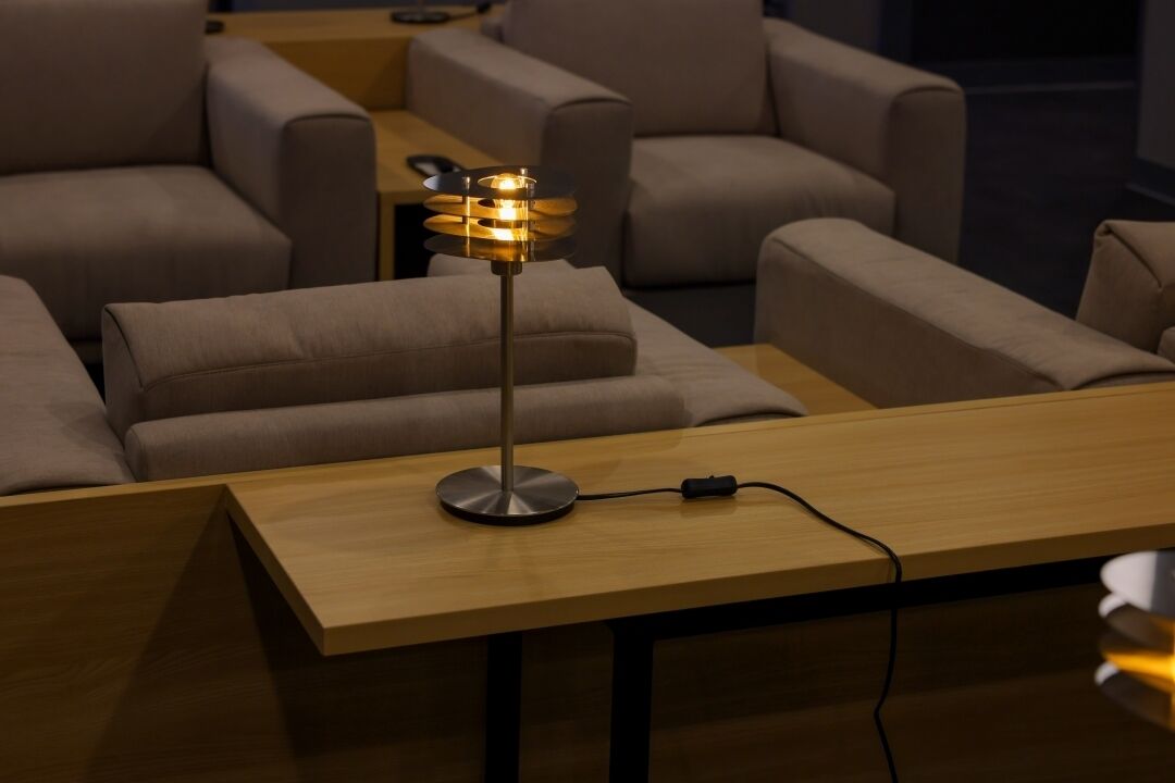 Una sala de estar moderna con una mesa de centro de madera, una lámpara de pie y sofás color beige.