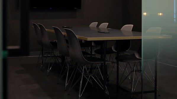 A conference room with a rectangular table and six chairs.