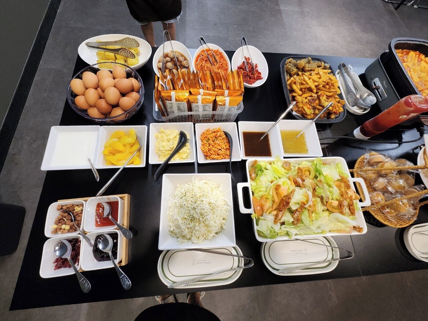 Una mesa de buffet con diversos alimentos y salsas.