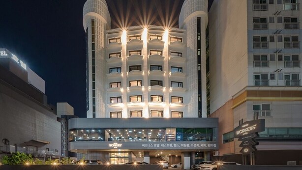 Un hôtel au design moderne, doté d’une tour centrale avec de nombreux balcons et d’une entrée au niveau du sol avec une façade en verre.