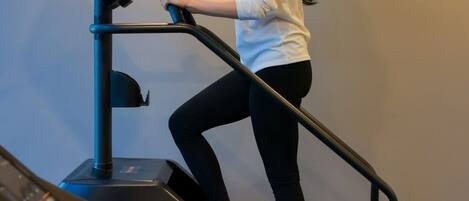 A woman using a treadmill in a gym with a control panel and a digital display.