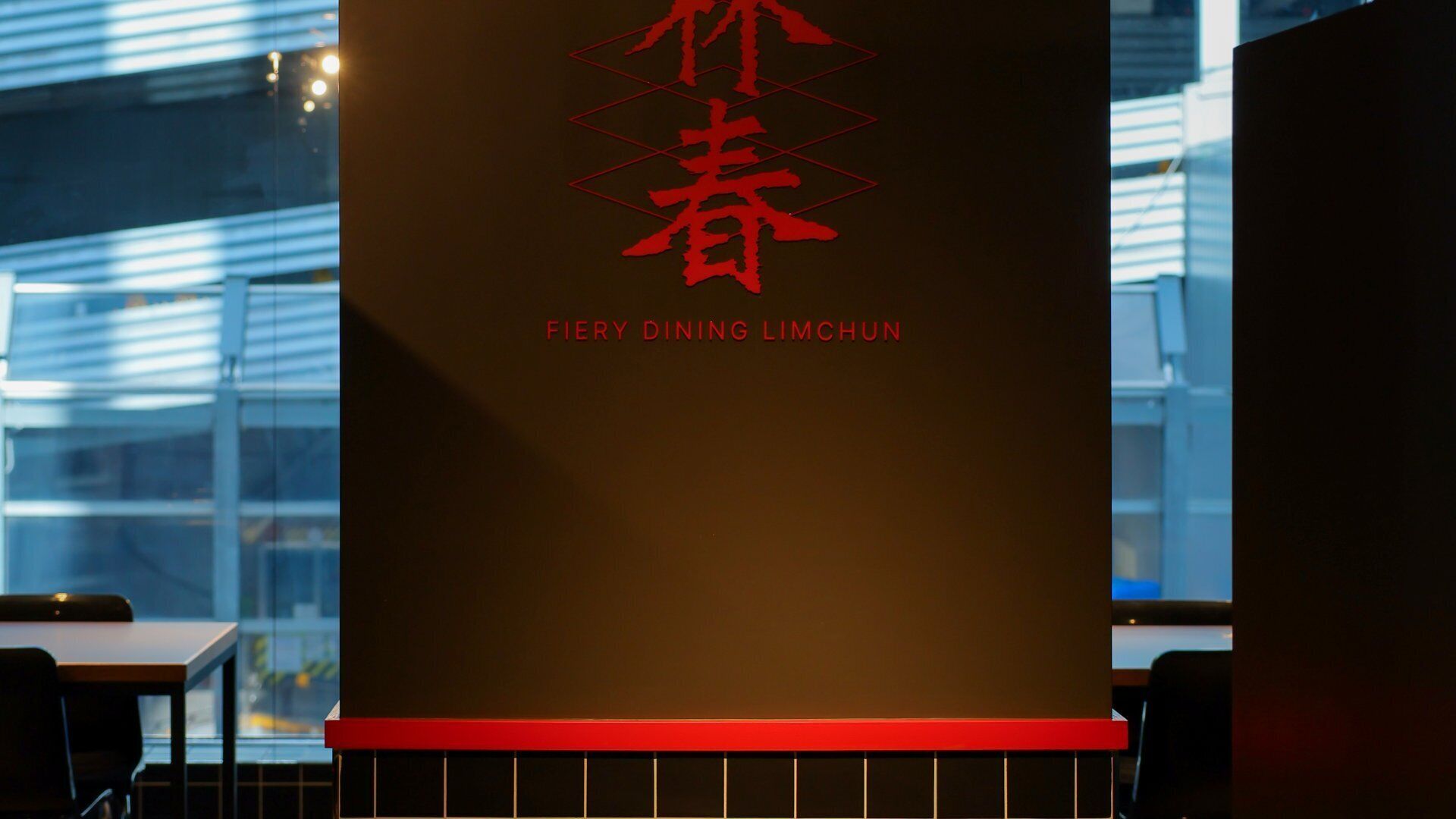 Un interior de restaurante con un letrero que dice 'FIERY DINING LIMCHUN'.