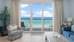 A living room with a view of the ocean, a sofa, a chair, and a coffee table. - Seychelles 703 | Beach Chair Service Included at this 7th Floor, Oceanfront Condo (Panama City Beach)