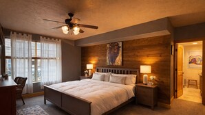 A bedroom with a bed, bedside lamps, a ceiling fan, a window with curtains, and a wooden accent wall. - 5 minute walk to shops! Great Location and private garage (Park City)