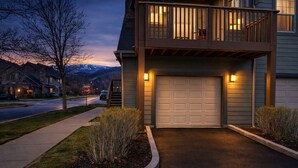 A two-story house with a garage, a balcony, and a stop sign in the background. - 5 minute walk to shops! Great Location and private garage (Park City)