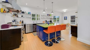 A modern kitchen with a central island, bar stools, and a dining area with a view. - Sullivan Farm at Helton Creek - Fire Pit - Foosball - Fireplace (Lansing)