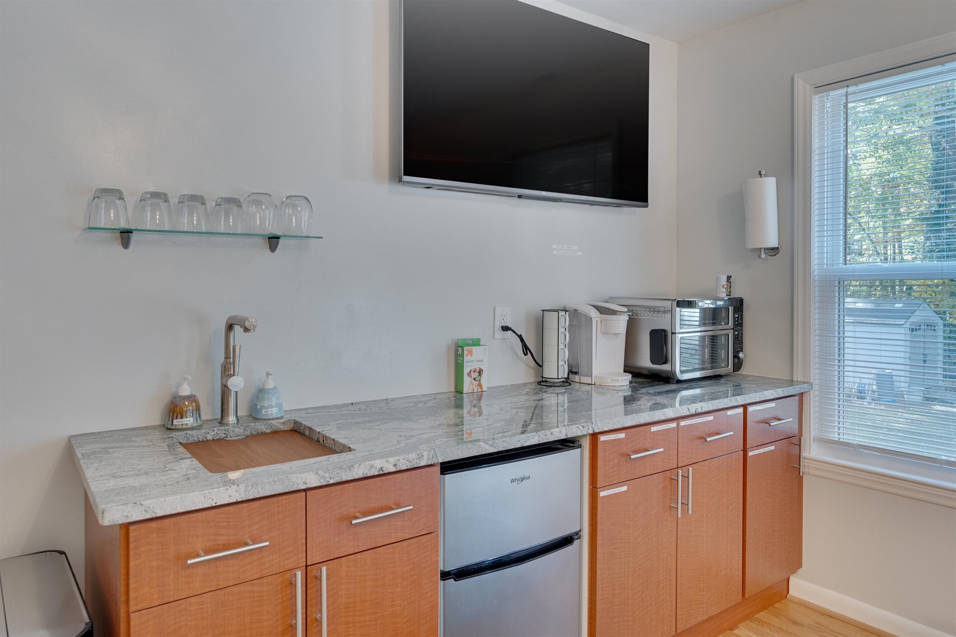 A modern kitchen with a built-in dishwasher, a coffee maker, and a microwave.