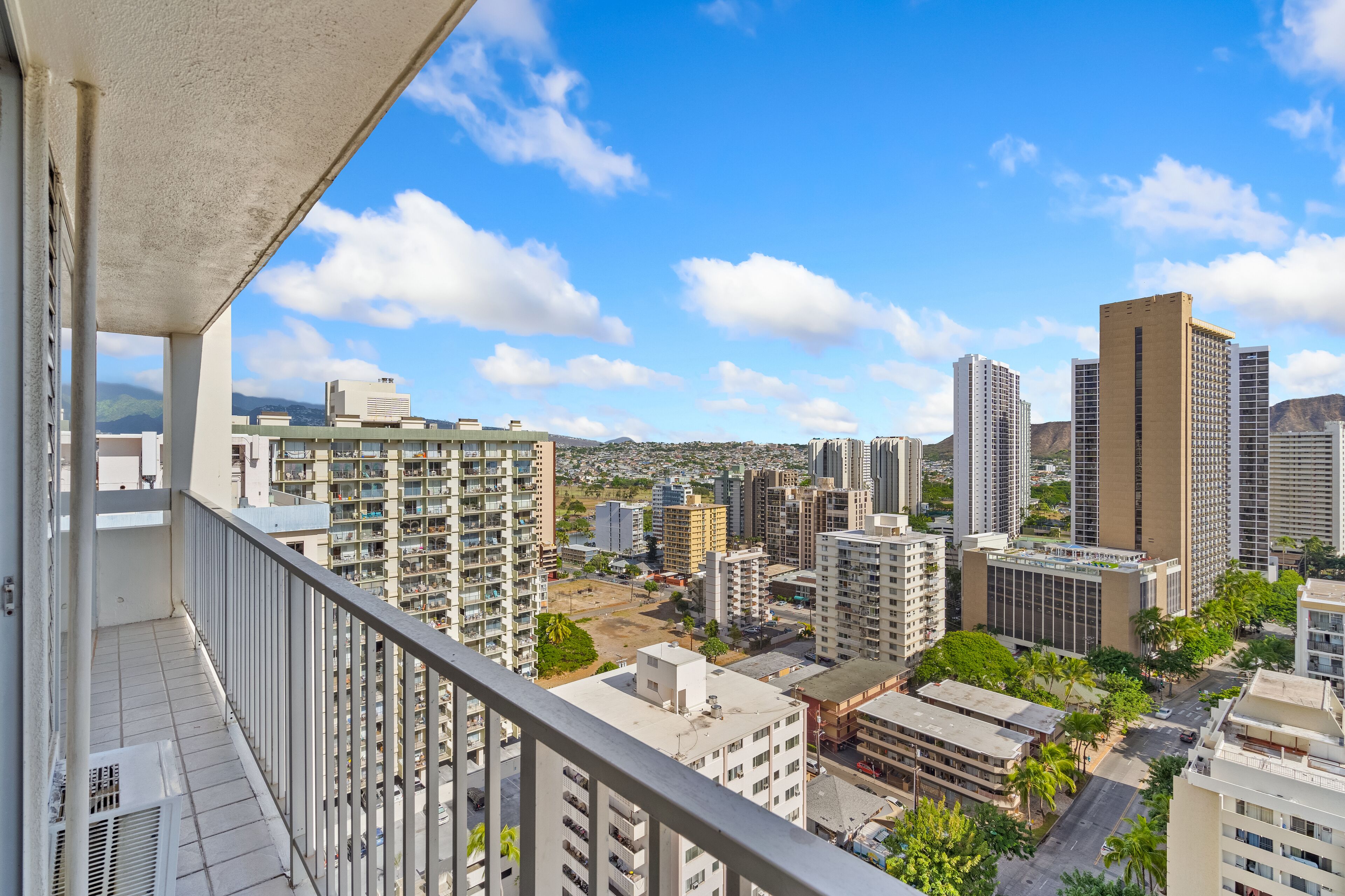 A high-rise building with a balcony overlooking a cityscape.