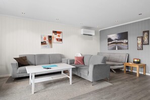 A living room with a grey sofa, a white coffee table, and a small wooden side table.