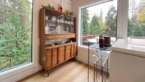 A room with a wooden cabinet, a glass display case, and a dining area with a table and chairs.