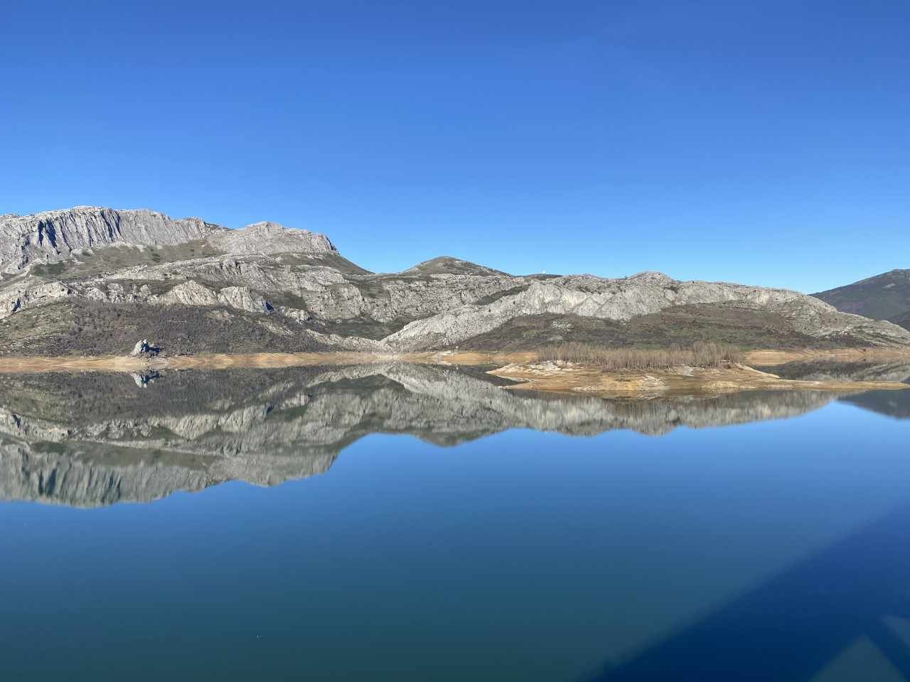 Un lago tranquilo que refleja claramente las montañas circundantes.