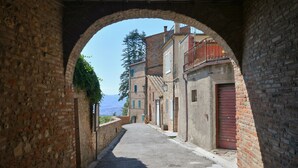 A narrow alleyway with brick buildings, a red door, and a clear sky.