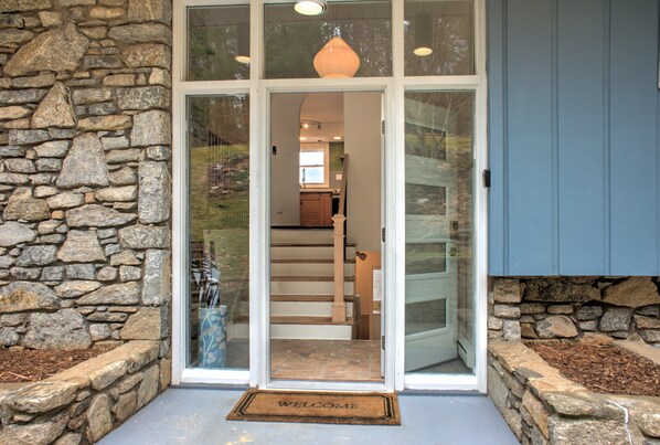 A stone exterior wall, a glass door entrance, a staircase, and a blue exterior wall.