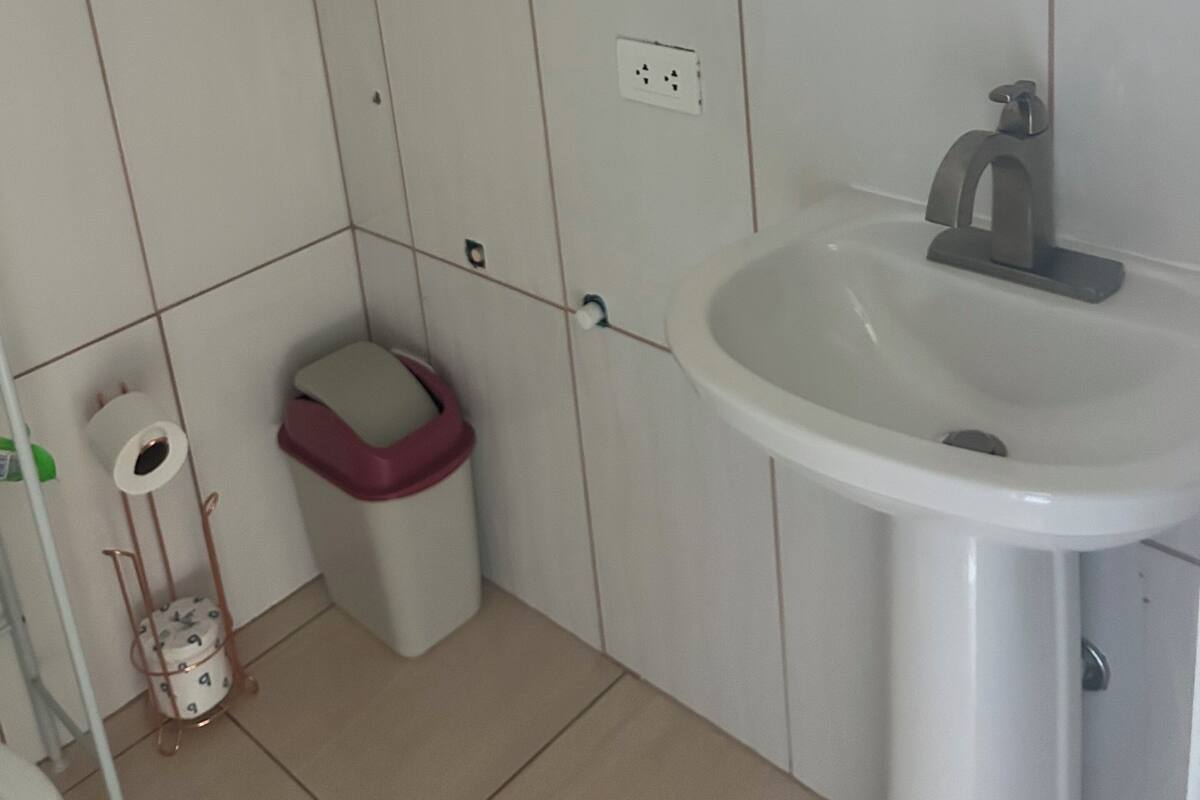 Ein Badezimmer mit einem weißen Waschbecken, einem Spiegel und einer Toilette.