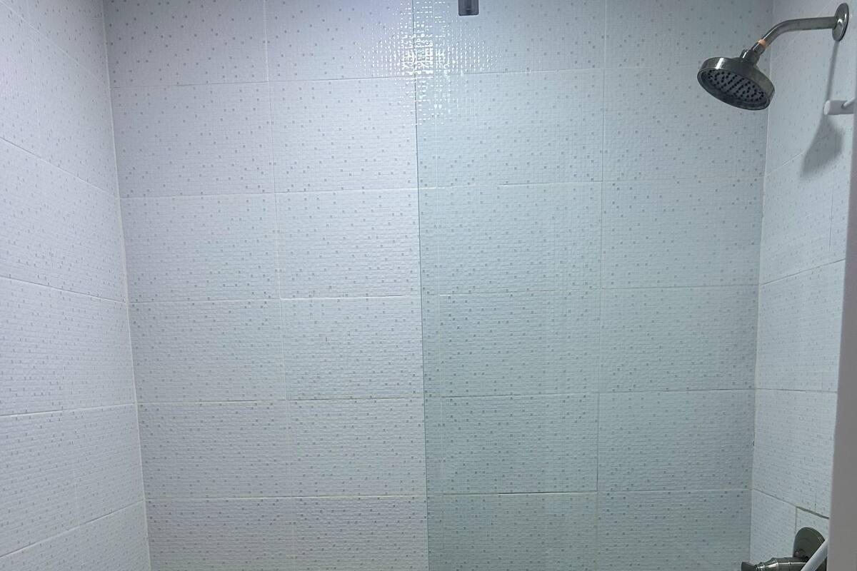 Ein kleines Badezimmer mit Fliesen, einer Dusche, einer Toilette und einem Waschbecken.