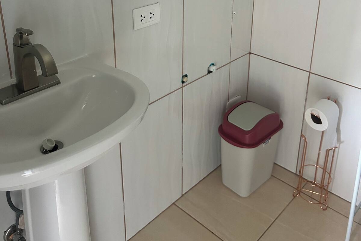 Ein Badezimmer mit einem weißen Waschbecken, einer Toilette und einem Spiegel.