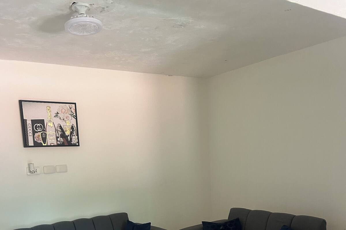 Ein Wohnzimmer mit zwei grauen Sofas, einem weißen Couchtisch und einer Wandleuchte.