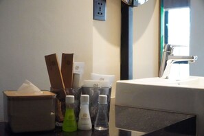A bathroom counter with toiletries, a tissue box, and a mirror. - Posto Dormire Benhil (Jakarta)