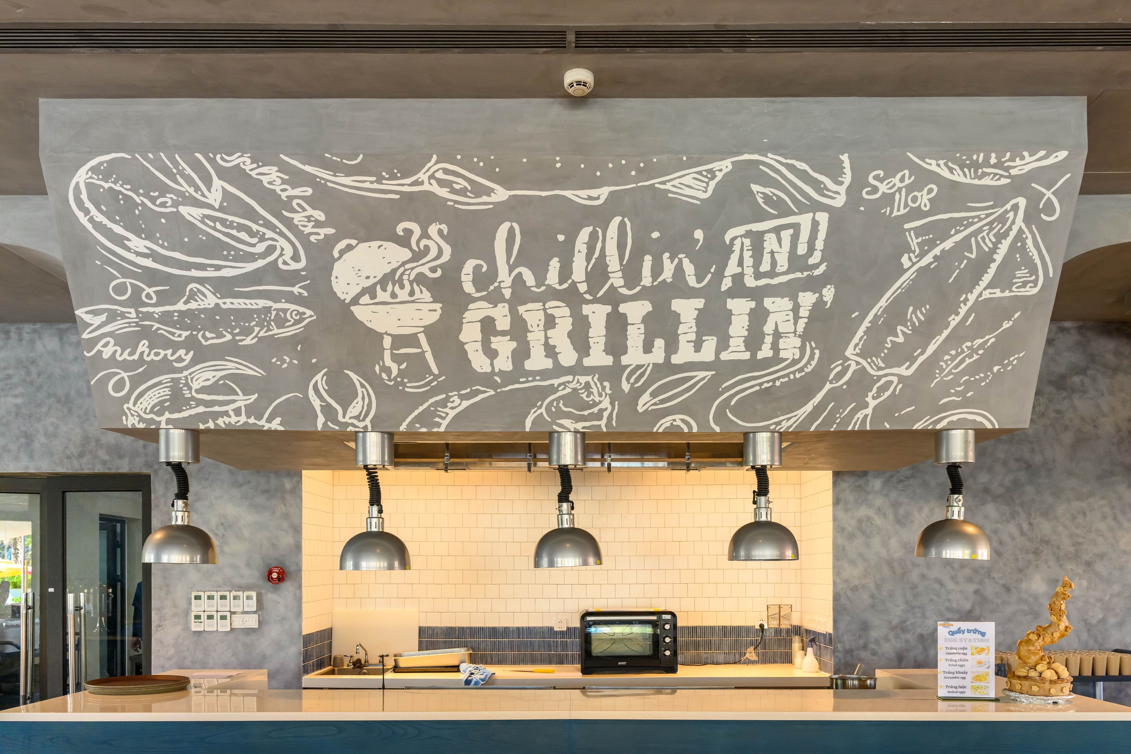 A kitchen with a chalkboard sign that reads "chillin' at the GRILLIN'".