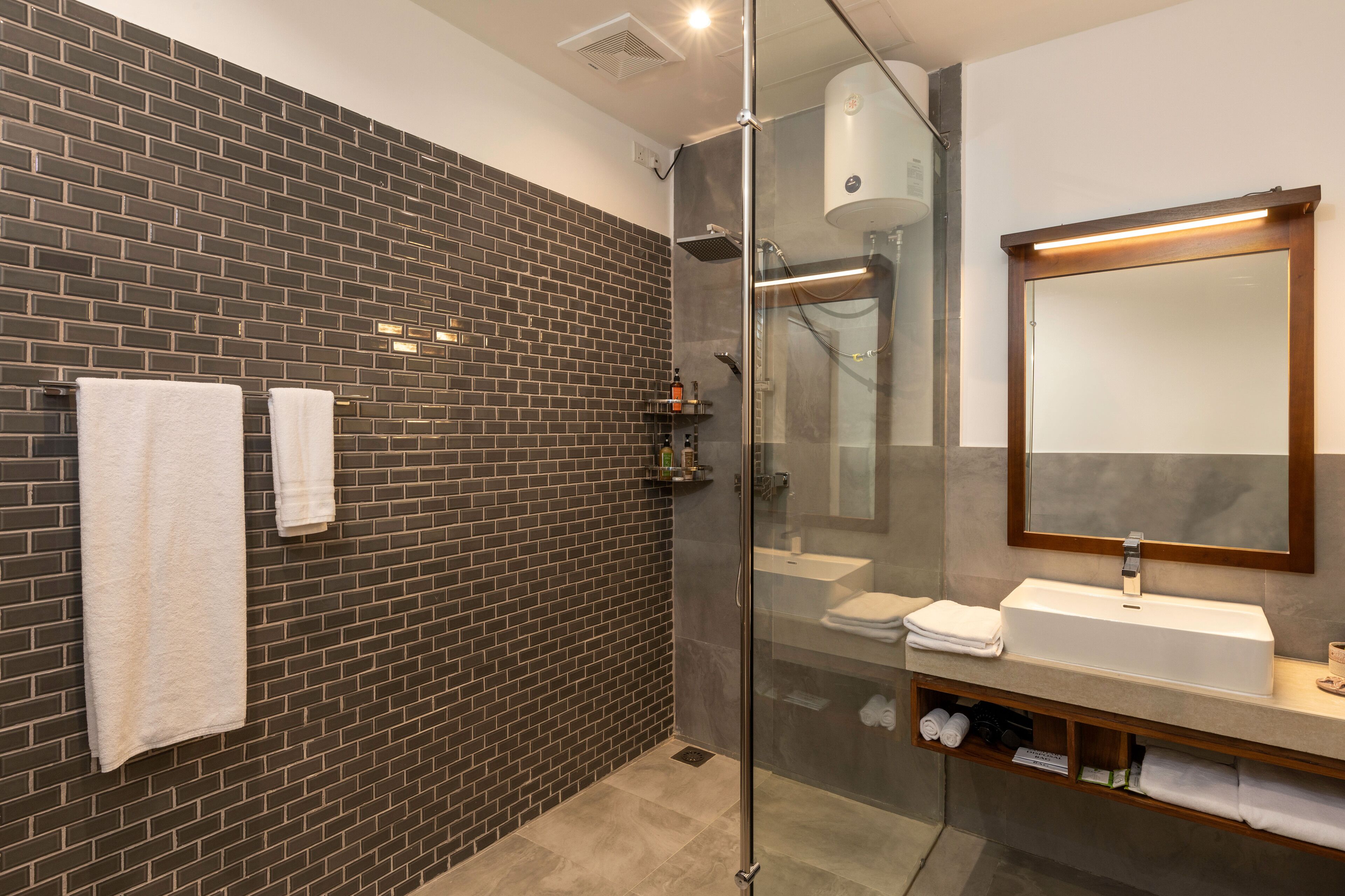 A modern bathroom with a glass-enclosed shower, a large mirror, and a built-in sink.