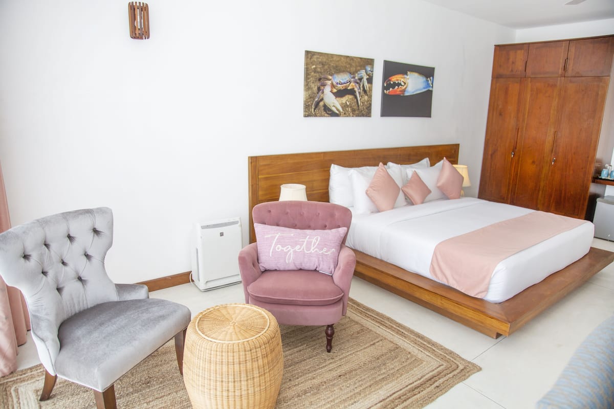 A bedroom with a bed, a chair, a bedside table, and a wardrobe.