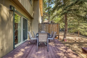 A deck with a table and chairs, a wooden fence, and a large tree. - Walk to beach, HOA amenities - 3 Bears, Tahoe City, (Tahoe City)