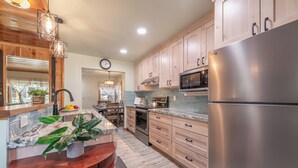 A modern kitchen with wooden cabinets, stainless steel appliances, and a marble countertop. - Walk to Beach and Town, Dogs OK, Cozy Fireplace, -Steelhead Mountain Retreat (Kings Beach)