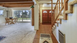 Ein großzügiger Wohnbereich mit Esstisch und Stühlen, eine Treppe mit einem einzigartigen Teppichmuster und eine große Schiebeglasdoor, die auf eine Terrasse führt.