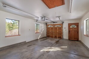 A spacious room with a large garage door, a wooden ceiling, and a concrete floor. - Dogs Ok, Private Sauna, Access to Backside of Alpine -Sherwood Star Lodge (Tahoe City)