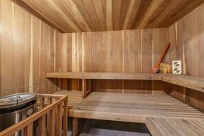 A sauna with wooden walls and benches, a heater, and a wooden spoon. - Dogs Ok, Private Sauna, Access to Backside of Alpine -Sherwood Star Lodge (Tahoe City)