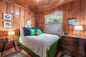 A wooden-paneled bedroom with a bed, pillows, a dresser, a lamp, and framed pictures on the wall. - Lake View from Master Bedroom, Deck,  Hot Tub, HOA Beach Access -Scenic Solitude (Carnelian Bay)
