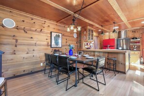 A wooden interior with a dining table, chairs, a kitchen area, and a bar. - Lake View from Master Bedroom, Deck,  Hot Tub, HOA Beach Access -Scenic Solitude (Carnelian Bay)